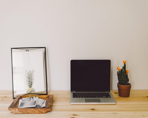 A well-organized and ergonomic home office desk setup with natural light and a supportive chair