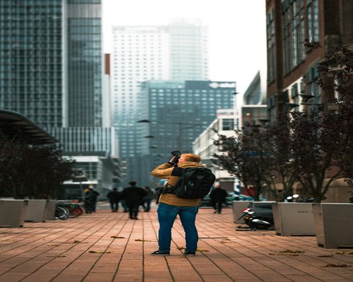 A person taking a mindful micro-break outdoors after commuting in a busy urban area